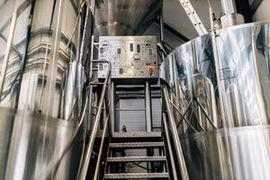 Industrial brewing setting with stainless steel tanks and a control panel